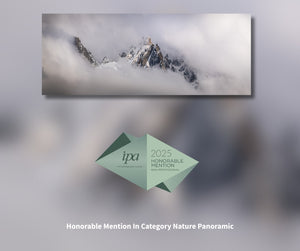 Mountains partially covered by clouds with IPA 2025 Honorable Mention badge.