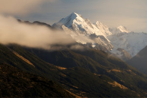 Snow-capped mountain peak with clouds in the foreground