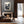 Modern living room with a fireplace, sofa, and scenic wall art.